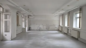 Großer, leerer Büroraum mit vielen Fenstern und Deckenbeleuchtung, bereit zur individuellen Gestaltung.