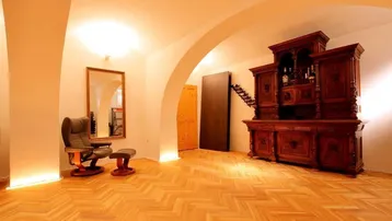 Geräumiger Kellerraum mit Gewölbedecken, Fischgrätparkett und traditionellen Möbeln, ideal als Weinkeller oder Aufenthaltsraum.