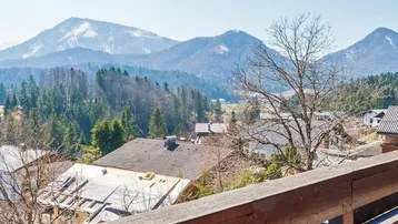 Panoramablick auf schneebedeckte Berge und die umliegende Landschaft von einem Balkon aus.
