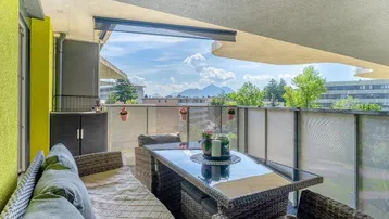 Möblierter Balkon mit Bergblick und gemütlicher Sitzgelegenheit im Freien, ideal zum Entspannen.