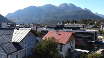 Panoramablick über die Dächer der Stadt auf die umliegende Berglandschaft.