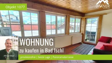 Gemütlicher Wohnbereich mit Holzbalkendecke, Fliesenboden und großen Fenstern, die viel Licht hereinlassen.