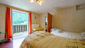 Schlafzimmer mit zwei Einzelbetten und Balkonzugang, bietet einen schönen Bergblick.