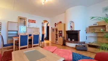 Gemütlicher Wohnbereich mit Kamin und Essbereich, eingerichtet mit Holzmöbeln.