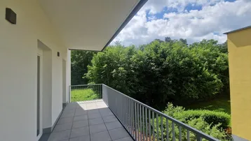 Geräumiger Balkon mit Fliesenboden und Blick ins Grüne, ideal zum Entspannen im Freien.