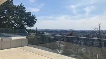Geräumige Terrasse mit Pool und weitem Blick über die Stadt und die umliegende Landschaft.