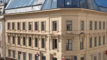 Elegantes Eckgebäude mit historischer Fassade und moderner Glasdachkonstruktion, die ein luxuriöses Penthouse beherbergt.
