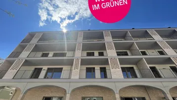 Moderne Gebäudefassade mit Balkonen und großen Fenstern unter blauem Himmel.