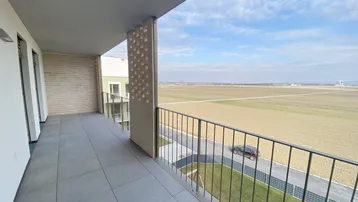 Geräumiger Balkon mit Fliesenboden und weitem Blick über Felder und die Landschaft.
