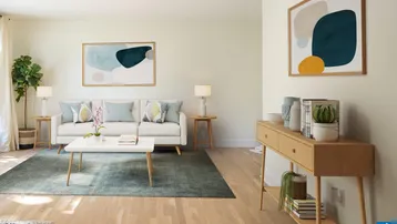 Helles, modernes Wohnzimmer mit hellem Holzboden, bequemer Couch und abstrakter Kunst an den Wänden.