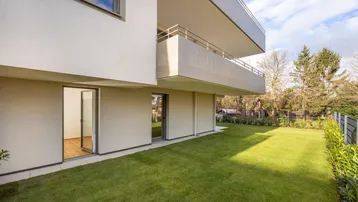 Moderne Wohnanlage mit gepflegtem Rasen und direktem Zugang zum Gartenbereich.