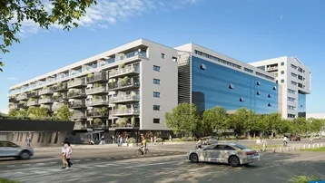 Moderne Wohnanlage mit Glasfassade und Balkonen an einer belebten Straße.