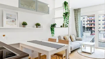 Helles, offenes Wohn-Esszimmer mit integrierter Küche, Parkettboden und Zugang zum Balkon.