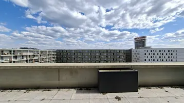 Geräumige Dachterrasse mit Fliesenboden und weitem Blick über die umliegenden Gebäude.