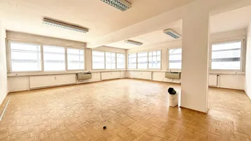 Großes, helles Büro mit vielen Fenstern und Parkettboden, bereit zur individuellen Gestaltung.