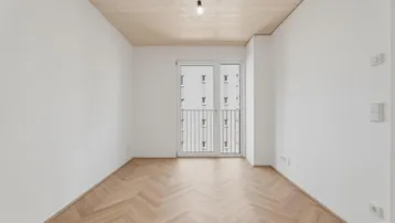 Helles Schlafzimmer mit Fischgrätparkett, weißen Wänden und einem französischen Balkon.