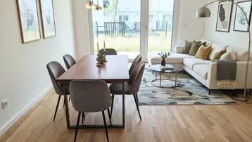 Heller Wohn- und Essbereich mit Holzboden, modernen Möbeln und Zugang zur Terrasse.