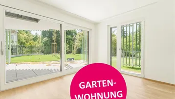 Helles Zimmer mit Holzboden und großen Schiebetüren zum Garten und zur Terrasse.