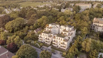 Moderne Wohnanlage mit Terrassen und Gründächern, umgeben von viel Grün und Bäumen.