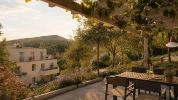 Sonnige Terrasse mit Pergola und Essbereich, umgeben von üppigem Grün und Blick auf die Hügellandschaft.
