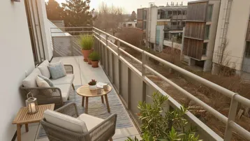 Geräumiger Balkon mit bequemen Loungemöbeln und weitem Blick ins Grüne.