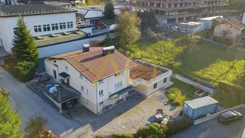 Luftaufnahme des Anwesens mit Wohnhaus, Nebengebäude und umliegender Landschaft.