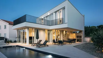 Moderne Villa mit großem Pool, Sonnenterrasse und Balkon, ideal für entspannte Abende.