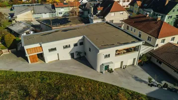 Moderne Wohnanlage mit Flachdach und umliegenden Häusern in ländlicher Umgebung.
