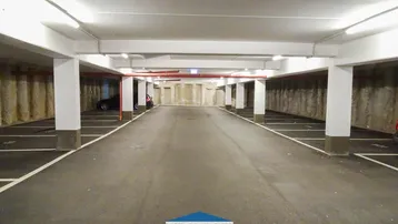 Geräumige Tiefgarage mit vielen Stellplätzen, guter Beleuchtung und massiver Bauweise.