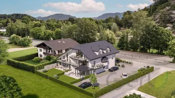 Luftaufnahme eines modernen Wohnhauses mit angrenzendem traditionellen Gebäude und gepflegter Gartenanlage.