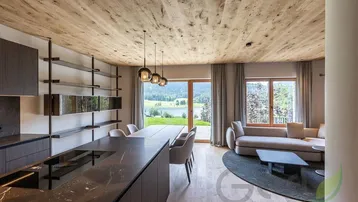 Moderner offener Wohn-Essbereich mit Holzbalkendecke, Seeblick und Zugang zur Terrasse.