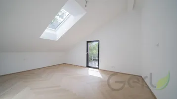 Geräumiges Zimmer im Dachgeschoss mit Schrägdach, Dachfenster und Zugang zu einem französischen Balkon.