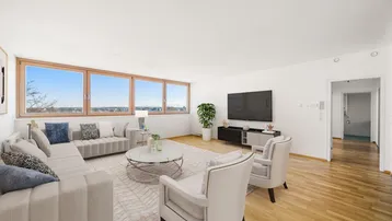 Helles, modern eingerichtetes Wohnzimmer mit Holzboden und weitem Ausblick durch große Fenster.