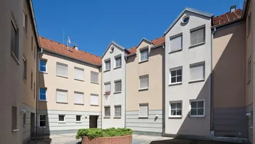 Innenhof des Gebäudekomplexes mit kleiner Grünfläche und umliegenden Fassaden.