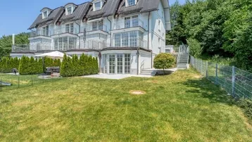 Elegantes Mehrfamilienhaus mit gepflegtem Gartenbereich und mehreren Balkonen in sonniger Lage.