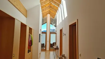 Heller Flur mit Holzboden, Einbauschränken und großzügigem Lichteinfall durch Dachfenster.