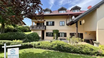 Großzügiges Einfamilienhaus mit traditioneller Architektur, rotem Ziegeldach und gepflegtem Vorgarten.
