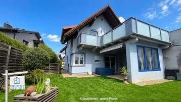 Freistehendes Einfamilienhaus mit Garten, Balkon und Terrasse unter blauem Himmel.