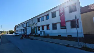 Gebäudeansicht von der Straße mit einem mehrstöckigen Bau, der Büros oder Gewerbeflächen beherbergen könnte.
