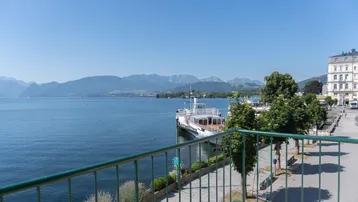 Geräumiger Balkon mit Blick auf den See und die umliegenden Berge, ideal zum Entspannen.