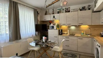 Moderne Küchenzeile mit Essbereich und integriertem Schlafbereich in einem hellen Studioapartment.