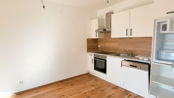 Moderne Einbauküche mit weißen Schränken, Holzrückwand und integrierten Geräten.