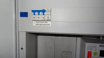 Sicherungskasten mit Schalter für den Photovoltaik-Wechselrichter, zeigt moderne Energieinfrastruktur.