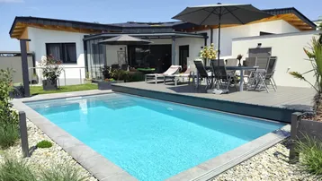 Moderner Außenbereich mit Swimmingpool, Holzterrasse und Gartenmöbeln unter Sonnenschirmen.
