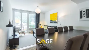 Helles Wohn- und Esszimmer mit großem Esstisch, Sofa und Zugang zum Balkon.