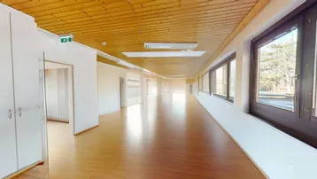 Geräumiger, leerer Raum mit Holzdecke und Holzboden, ideal für Büronutzung oder vielseitige Zwecke.