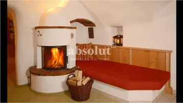Gemütlicher Wohnbereich mit traditionellem Kamin und integrierter Sitzbank, ideal für entspannte Abende.