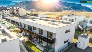 Moderne Reihenhäuser mit privaten Gärten und Terrassen in sonniger Lage mit Bergblick.