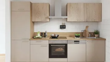 Moderne Einbauküche mit hellen Holzfronten, integrierten Geräten und Fliesen-Rückwand.