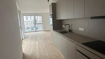 Moderne offene Küche mit hellen Holzfußböden und Blick auf die Stadtstraße.